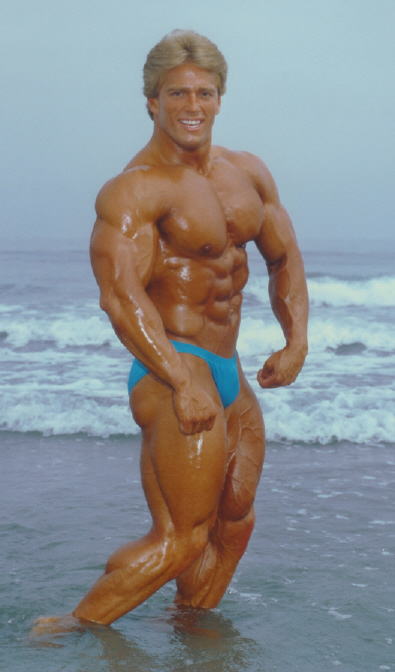 Color photo of Joe Meeko at the beach hitting a pose